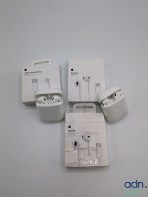 quatre AirPods blancs « Apple » posés les uns à côté des autres sur une surface blanche