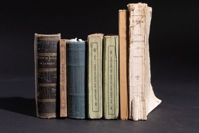 Plusieurs vieux livres sont empilés les uns sur les autres sur une surface noire