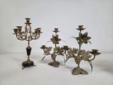 three antique brass candelabs with flowers and leaves on them