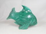 a green ceramic fish that is sitting on a white surface