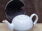 a white teapot sitting on a wooden table