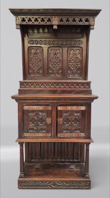 une vieille armoire en bois ornée de sculptures sur le dessus