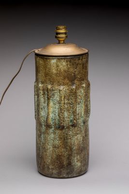 un vase marron et vert sur lequel est posée une lampe