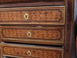 a tall wooden chest of drawers with a baseball bat on top of it