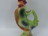 une figurine représentant un coq sur fond blanc