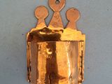 une clochette en or accrochée au mur, surmontée d'une couronne