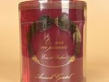 a red tin with a bow on it sitting on a table