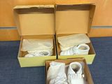 deux cartons contenant des chaussures, posés par terre