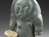 a statue of a man holding a brush and a bowl