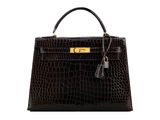 a black crocodile skin handbag with gold hardware