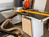 une photo d'une machine en train de scier un morceau de bois
