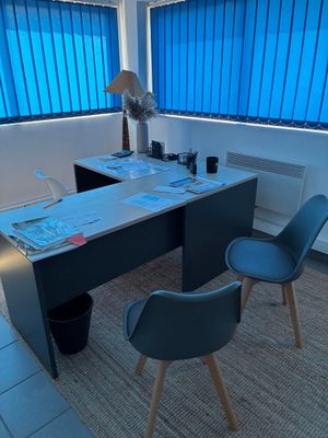 un bureau avec deux chaises et un ventilateur dans une pièce