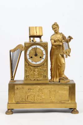 une horloge en or représentant une femme tenant une harpe