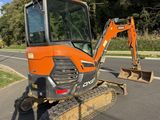 an orange tractor that is parked on the side of the road