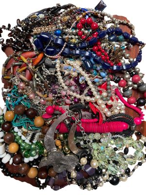 une pile de bijoux assortis sur une surface blanche