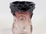 a glass vase that has a black and pink design on it