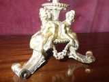 brass figurine on a wooden table with a purple background