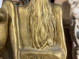 a gold statue of a woman with long hair