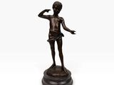 une statue en bronze représentant un garçon levant la main