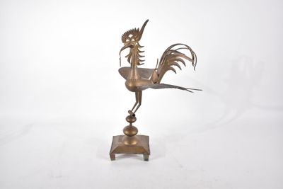 une statue représentant un coq posée sur un socle, sur fond blanc