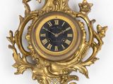 a gold clock with a black face and gold decorations
