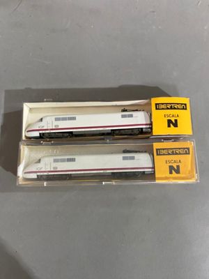 Deux trains miniatures sont posés dans une boîte sur une table