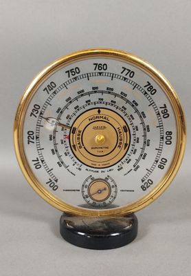 une horloge dorée et blanche posée sur un socle noir