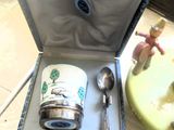 une boîte contenant une tasse et une cuillère, posée sur une table