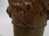 un vase en bronze orné d'animaux, posé sur une table