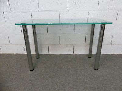 une photo d'une table en verre avec des pieds en métal