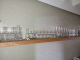 many glasses on a shelf in the kitchen
