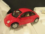 une petite voiture rouge posée sur une surface blanche