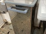 a trash can sitting next to a trash can in a kitchen