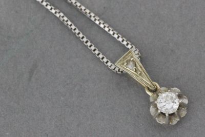 un gros plan d'un pendentif en diamant suspendu à une chaîne, posé sur une table