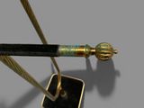 a gold and black pen with a black handle on a stand