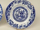 two blue and white plates with designs on them