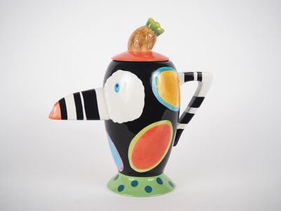 un vase noir et blanc surmonté d'un oiseau