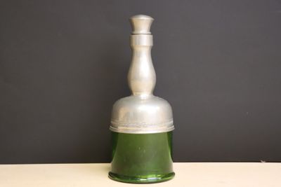 une bouteille en verre vert avec un bouchon argenté posée sur une table