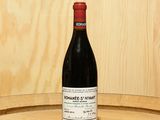 a bottle of wine sitting on top of a barrel