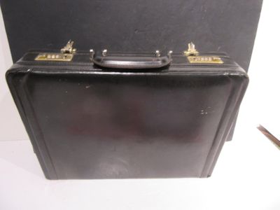 une mallette noire posée sur une table blanche