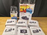 des boîtes d'appareils photo posées sur une table en bois, à côté d'un rideau noir