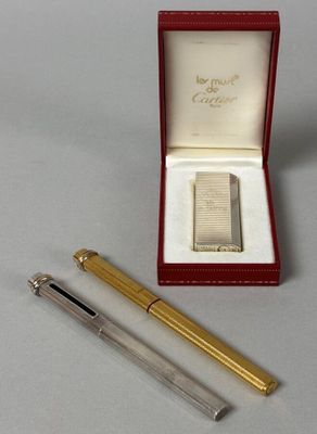 un stylo et un briquet dans une boîte posée sur une table