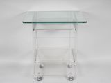 a clear glass side table with wheels on a white background