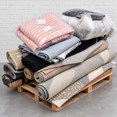 a pile of blankets and blankets on a pallet next to a wall