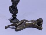 statue en bronze représentant une femme allongée sur le dos à côté d'un buste d'homme