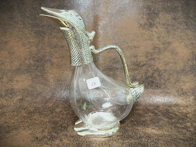 a glass vase with a bird inside of it on a table