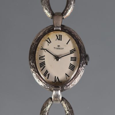 a silver clock with roman numerals on it