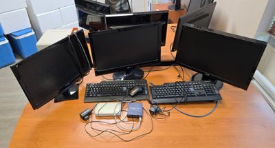 trois écrans d'ordinateur et un clavier posés sur un bureau