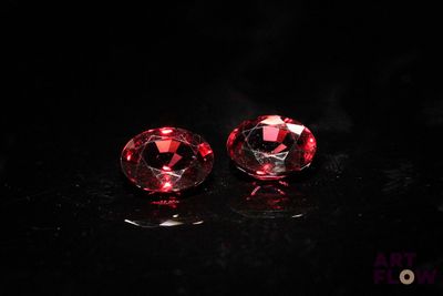 a pair of red gems on a black surface
