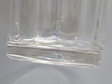 a clear glass bottle with a small amount of liquid in it